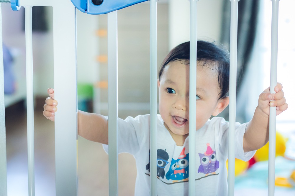 Toddler waiting at home safety gate